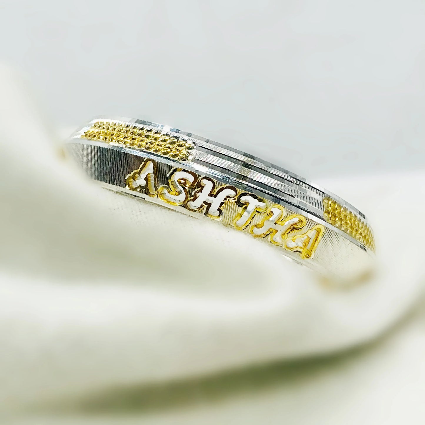 Silver and gold bracelet with the name Ashtan engraved in gold letters