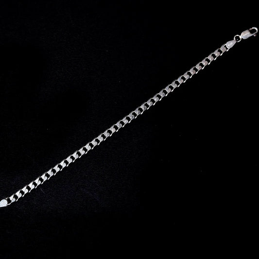 Silver Cuban link chain bracelet with lobster clasp on black background