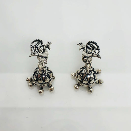 Pair of oxidized silver earrings with intricate peacock design and dangling decorative elements
