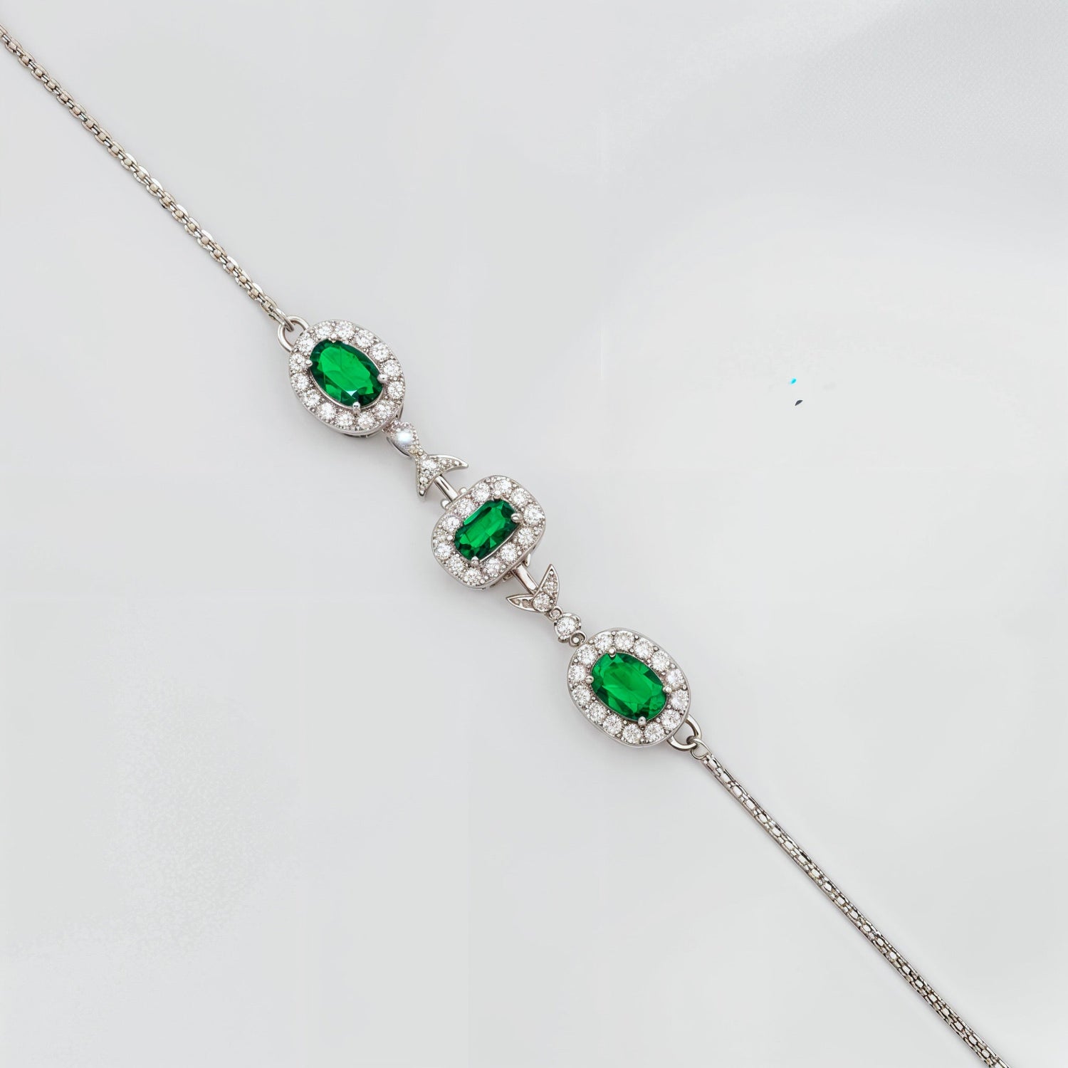 Elegant silver bracelet with pear-shaped red gemstone and diamond accents on white background