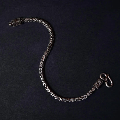 Elegant silver chain bracelet with intricate woven link design on black background