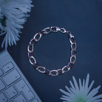 silver chain bracelet on black surface with white flowers and keyboard edge