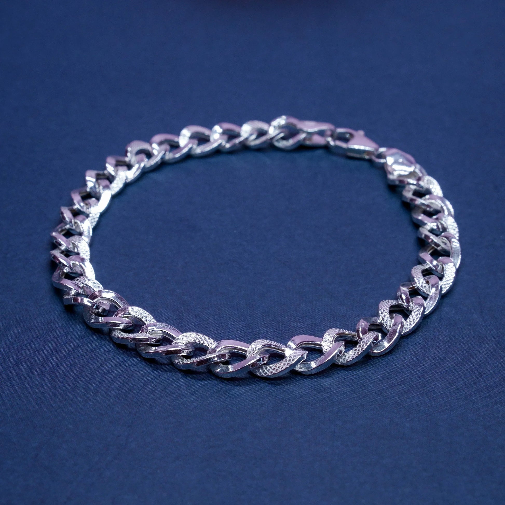Silver textured chain bracelet on dark blue background, men's fashion jewelry