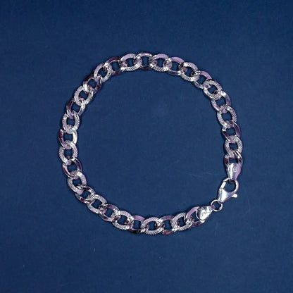 Silver chain bracelet with textured and smooth oval links on a dark blue background