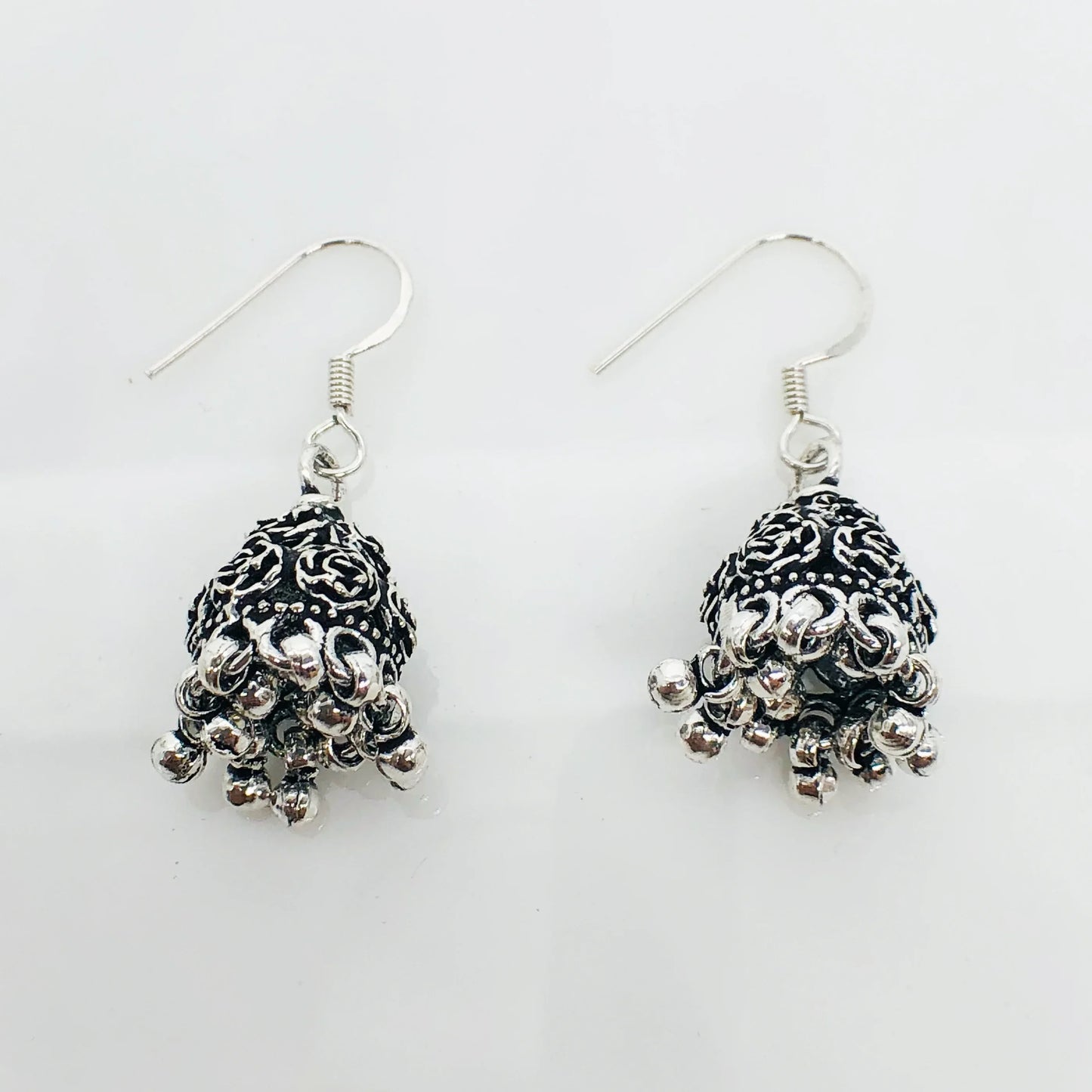 Silver oxidized jhumka earrings with intricate floral design and dangling beads