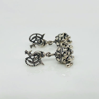 Intricate oxidized silver jhumka earrings with peacock design and dangling beads
