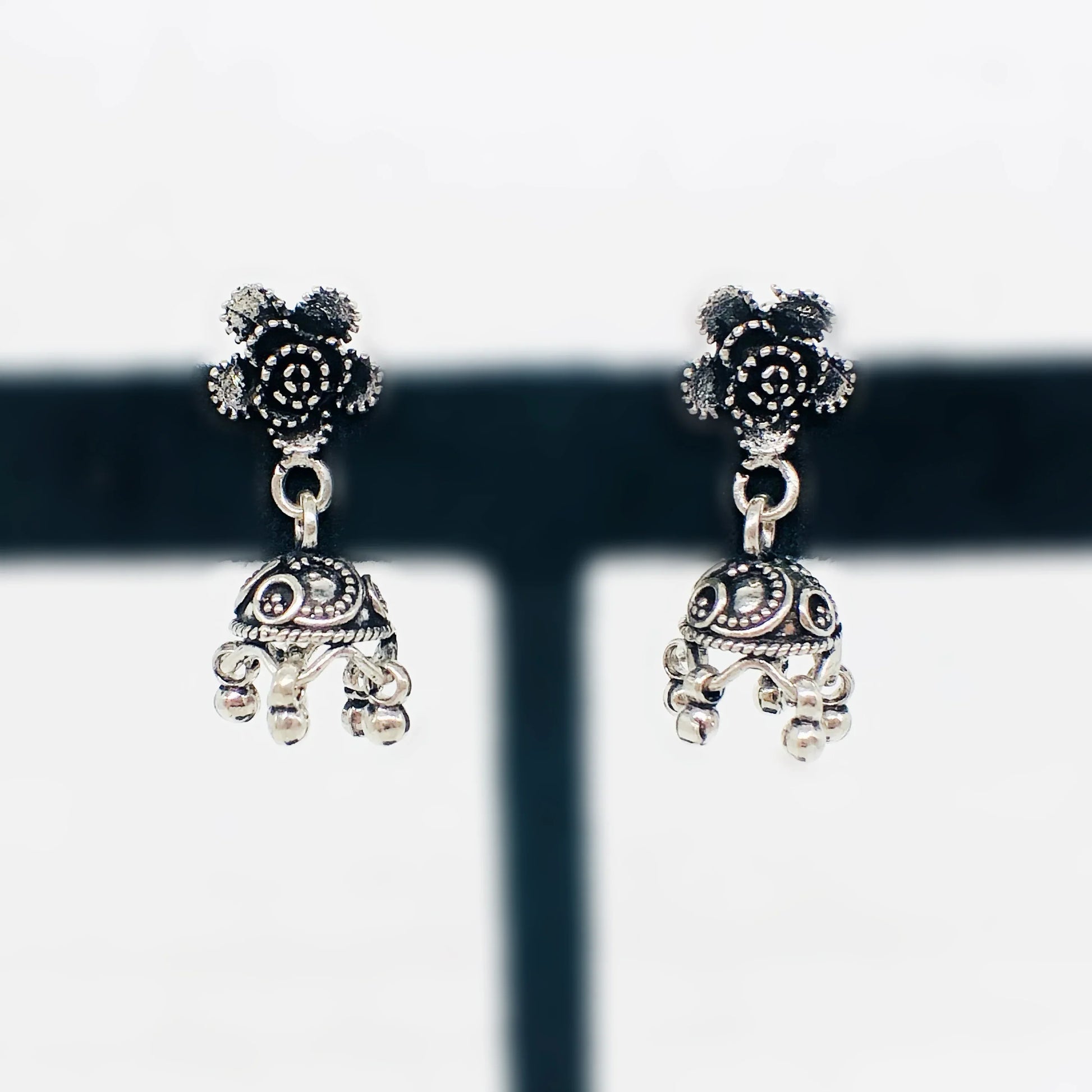 Silver antique jhumka earrings with floral stud and intricate dome design